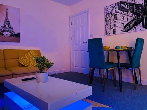 a living room with a couch and a table at GB Relocations Ltd - Award Winning Merridale Executive Apartment, Free Parking, Free WiFi, Free Netflix in Wolverhampton