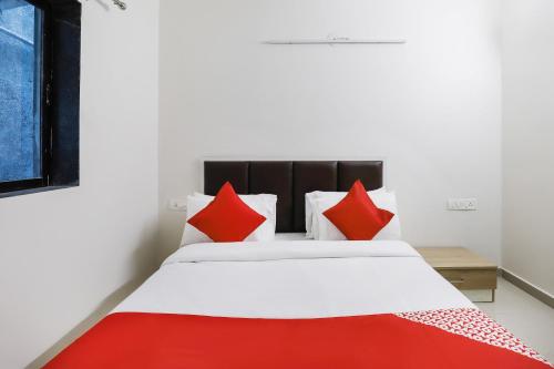 a bedroom with a bed with red pillows at Hotel O Zion Inn in Vapi