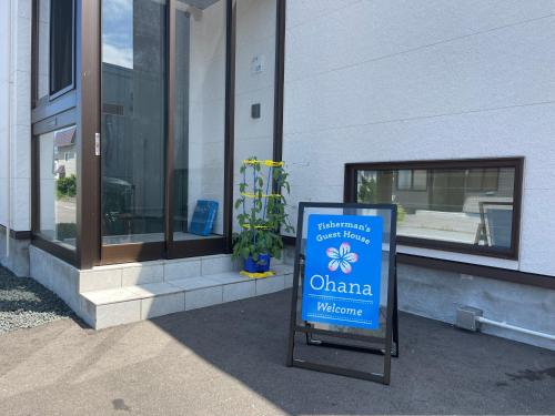 a sign in front of a building with a window at オホーツクの海の幸が食べられる 漁師の家ゲストハウスOhana in Abashiri