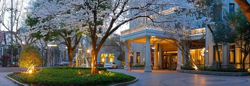 a building with trees in front of it with lights at Shanghai Donghu Hotel - Shanghai Style Garden House in Shanghai