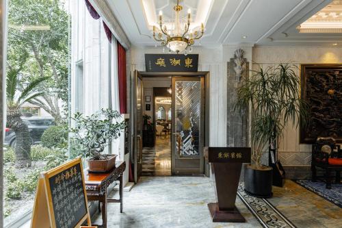 a hallway with a door with a chandelier at Shanghai Donghu Hotel - Shanghai Style Garden House in Shanghai