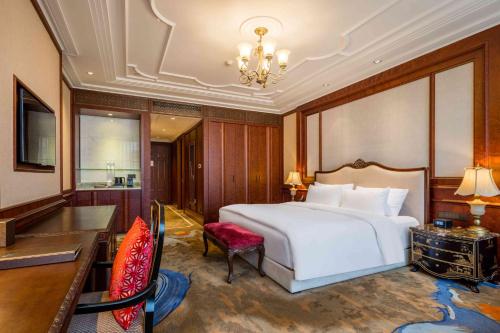 a bedroom with a large white bed and a desk and a chair at Shanghai Donghu Hotel - Shanghai Style Garden House in Shanghai