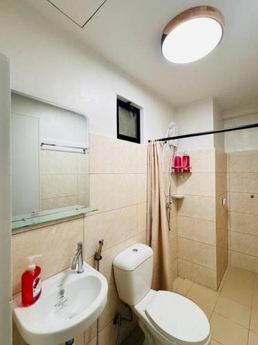 a bathroom with a white toilet and a sink at DHub Space Panglao in Dauis