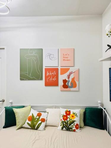 a white room with pictures on the wall and pillows at DHub Space Panglao in Dauis