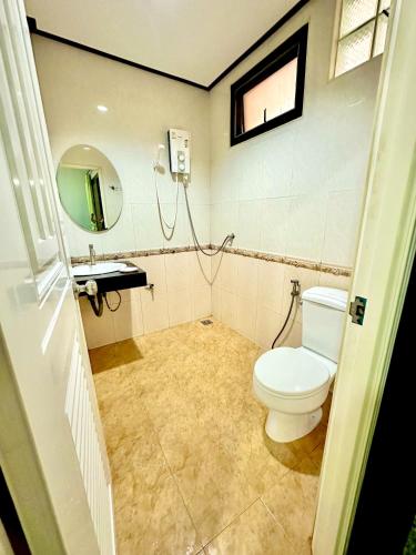 a bathroom with a toilet and a sink at โรงแรมกาญจนาสกลนคร in Sakon Nakhon