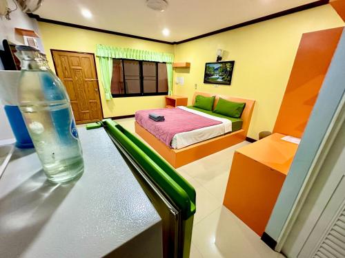 a bedroom with a bed and a bottle of water on a table at โรงแรมกาญจนาสกลนคร in Sakon Nakhon
