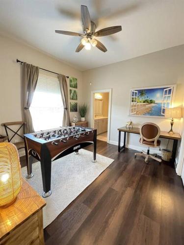 a living room with a table and a ceiling fan at Luxury Heated Pool Home, Hot tub, King bed suite in Lakeland