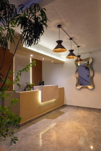 a lobby with two pendant lights and a counter at Hotel Casa Barcelona San Luis Potosí in San Luis Potosí