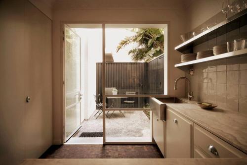 a kitchen with a door leading to a patio at Boutique Art Deco Apt, Beach, Park, Shops, Cafes F1 in Melbourne