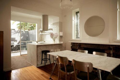 a kitchen with a table and chairs and a counter at Boutique Art Deco Apt, Beach, Park, Shops, Cafes F1 in Melbourne