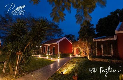 a house with lights in the yard at night at Hacienda Santa Cruz Merida in Mérida