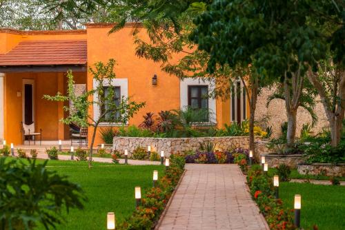 a garden with candles in front of a house at Hacienda Santa Cruz Merida in Mérida