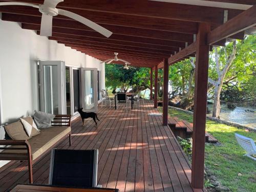 a covered deck with a couch and a table at Turtle Bay Beach House in Saraotou