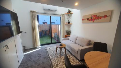 a living room with a couch and a table at Modern Loft in Christchurch CBD with Private Courtyard in Christchurch