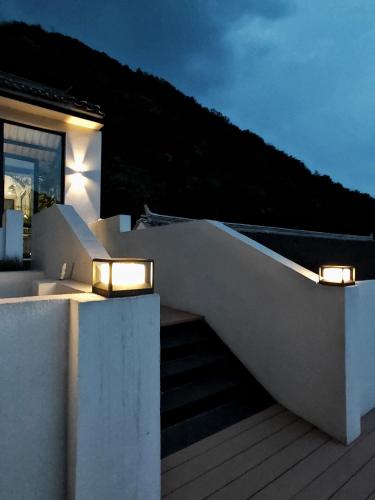 a white house with lights on the stairs at Beijing Wuji Inn - The Great Wall of China Huanghuacheng in Beijing