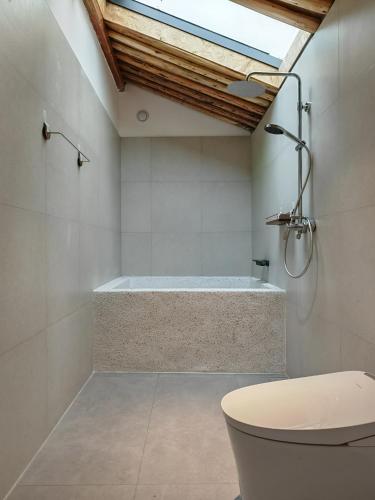 a bathroom with a bath tub and a toilet at Beijing Wuji Inn - The Great Wall of China Huanghuacheng in Beijing
