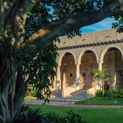 a building with arches and stairs in a yard at Hacienda Santa Cruz Merida in Mérida