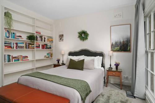 a bedroom with a large bed with book shelves at The Croft - Enchanting Bowral stone cottage in Bowral
