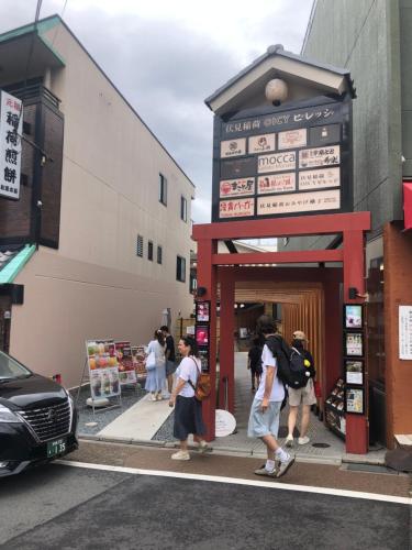 a group of people standing outside of a store at Inari-Home in Kyoto