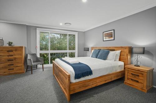 a bedroom with a large bed and a window at Time2Reflect - the most relaxing Bowral getaway! in Bowral