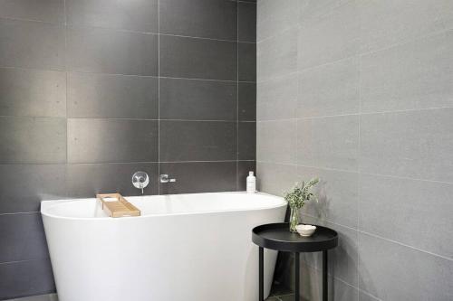 a bathroom with a bath tub and a black table at Teds Place Close to Bowral Town in Bowral