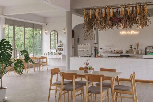 a kitchen and dining room with a table and chairs at Villa La Flora Kanchanaburi in Ban Hua Hin