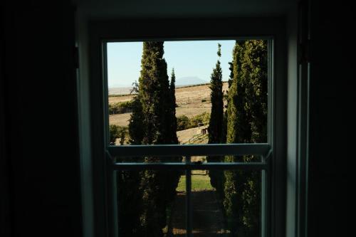 an open window with a view of trees at Gabriëlskloof Farm House in Botrivier