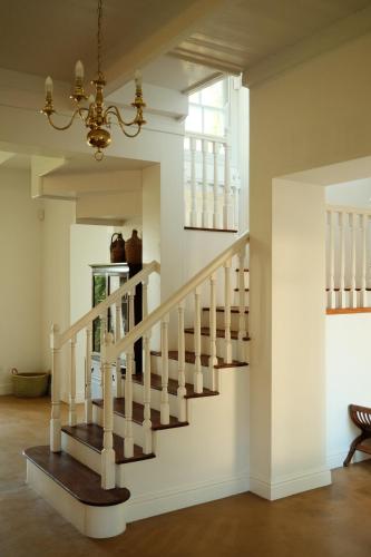 a staircase in a house with a chandelier at Gabriëlskloof Farm House in Botrivier