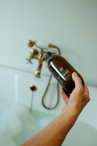 a person holding a hair dryer in front of a sink at Gabriëlskloof Farm House in Botrivier