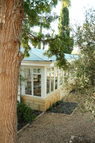 a white house with windows and a tree at Gabriëlskloof Farm House in Botrivier