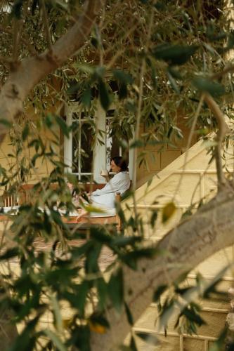 a man sitting on a bench in front of a window at Gabriëlskloof Farm House in Botrivier