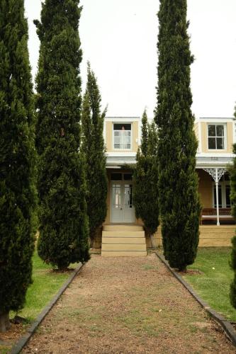 a house with a bunch of trees in front of it at Gabriëlskloof Farm House in Botrivier