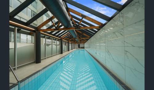 a large swimming pool with a glass ceiling and a ceiling at ReadySet Apartments at Southbank Condos in Melbourne
