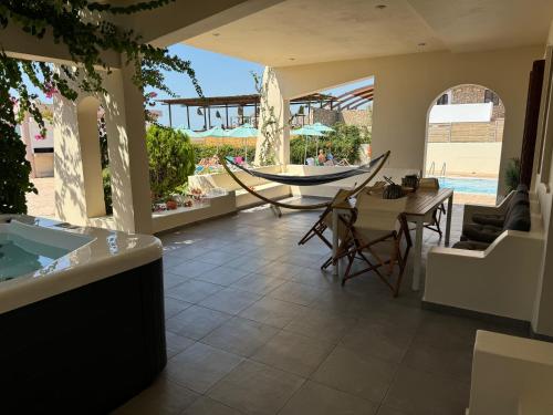a patio with a table and a hammock in a resort at Amaryllis Beach House in Lardos