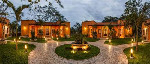 a house with a courtyard with a fountain and lights at Hacienda Santa Cruz Merida in Mérida