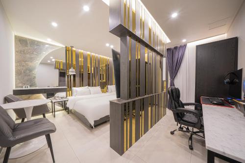 a hotel room with a bed and a desk and chairs at Brown Dot Hotel Sinan in Gwangju