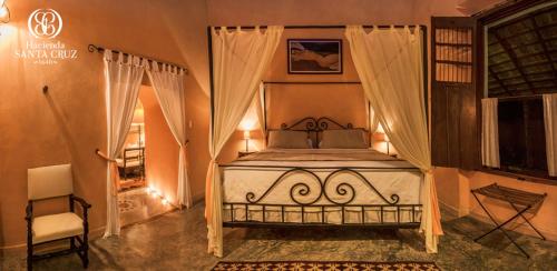 a bedroom with a bed and a chair in it at Hacienda Santa Cruz Merida in Mérida