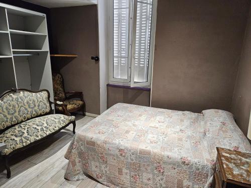 a bedroom with a bed and a chair and a window at Hôtel des Jacobines in Chalon-sur-Saône