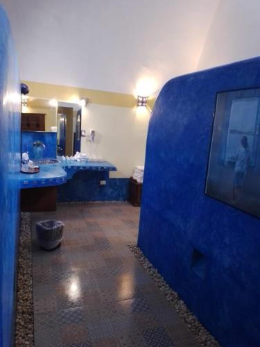 a bathroom with two sinks and a blue wall at Hacienda Santa Cruz Merida in Mérida