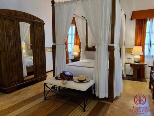 a bedroom with a bed and a table with a hat on it at Hacienda Santa Cruz Merida in Mérida