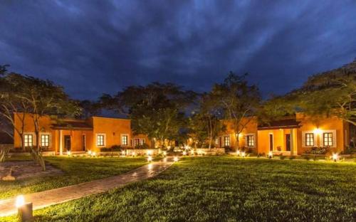 a house with lights in the yard at night at Hacienda Santa Cruz Merida in Mérida