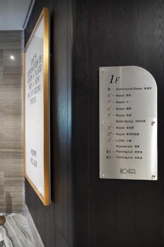 a sign on a wall with a thermometer on it at Boda Hotel in Taichung