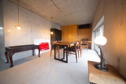 a dining room with a table and a piano at SENSE Beppuwan in Hiji