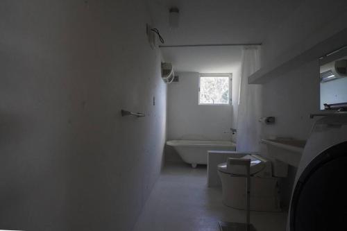 a bathroom with a tub and a toilet and a sink at SENSE Beppuwan in Hiji