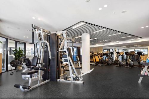 a gym with several tread machines in a room at Central located 1Bedroom Apartment in Woden By Serain Residences in Phillip