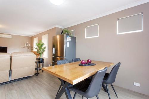a kitchen and dining room with a wooden table and chairs at Civic Gardens Villa in Perth