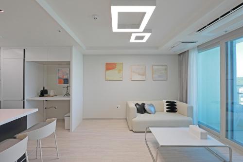 a living room with a couch and a table at Elmomento Songdo in Busan