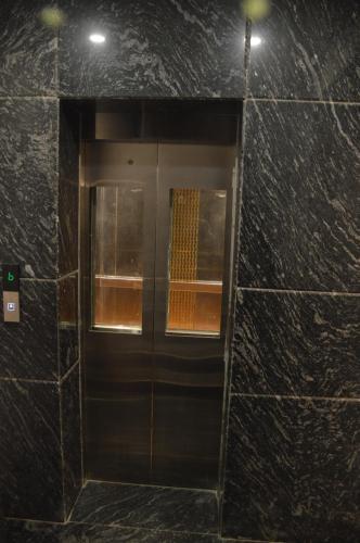 a elevator in a building with a glass door at The Rividium Hotel in Deoghar
