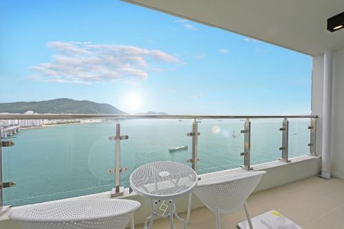 a balcony with a table and chairs and a view of the water at Elmomento Songdo in Busan