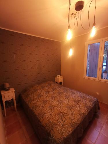 une chambre avec un lit dans une pièce avec une fenêtre dans l'établissement T2 indépendant terrasse et piscine au calme Var sud de la France, à Flassans-sur-Issole